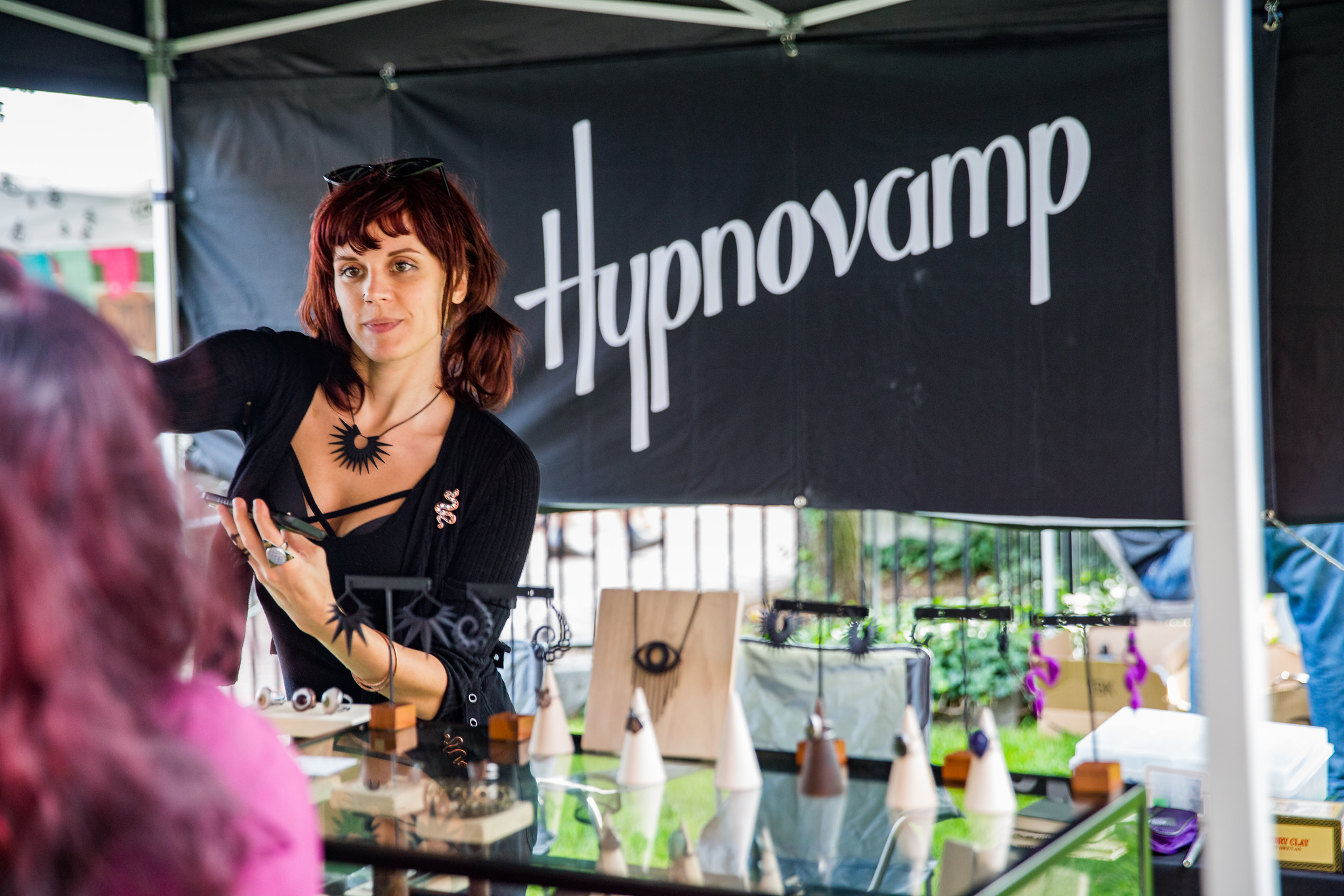 a woman standing in front of a table with a sign on it.