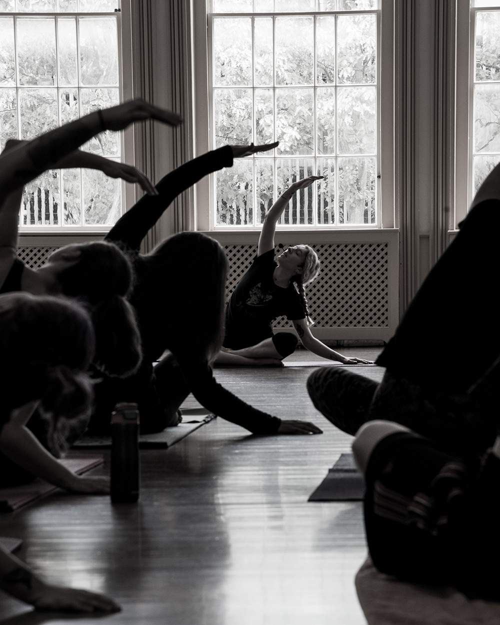 a group of people doing yoga in a room.