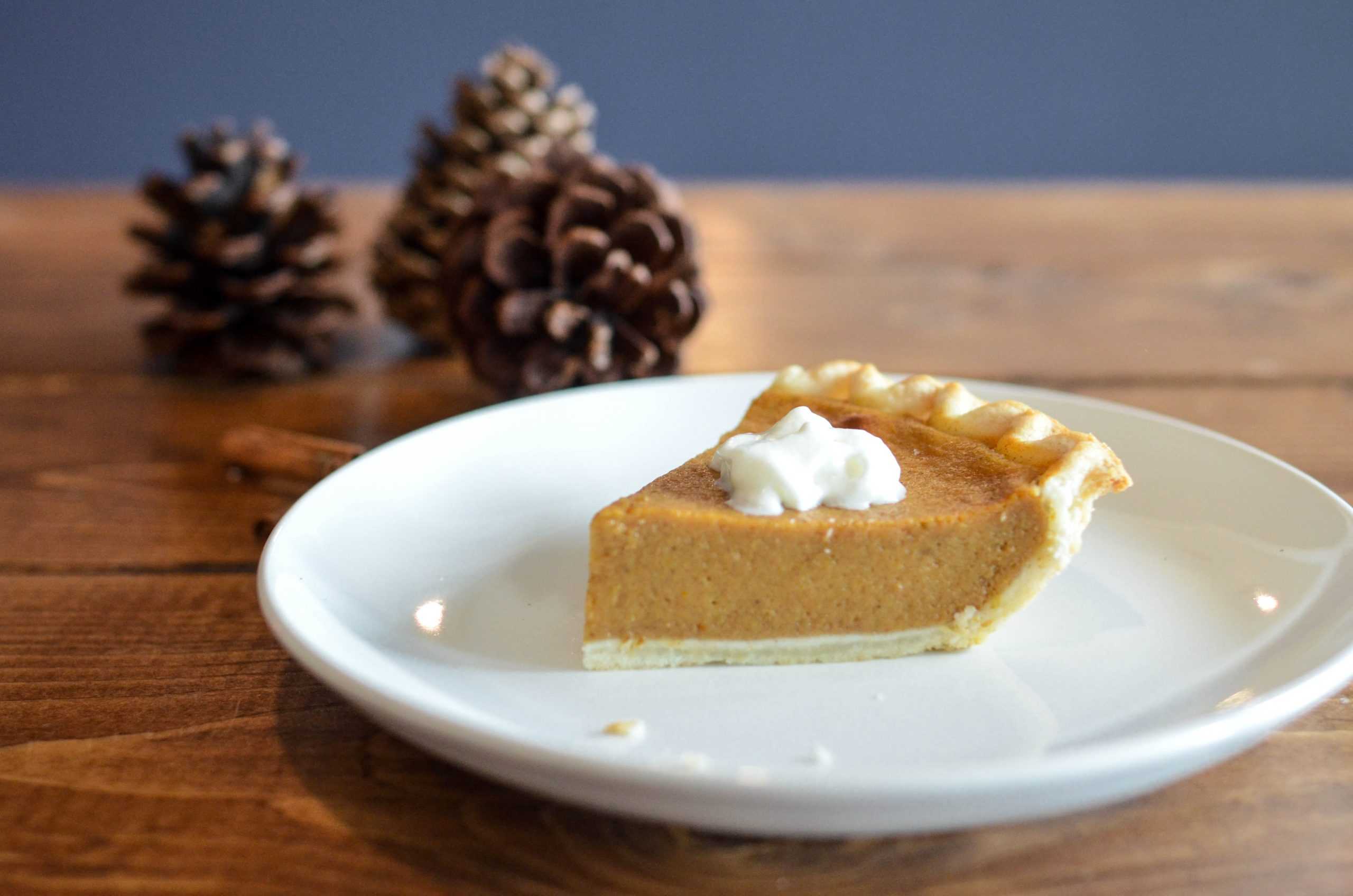 a slice of pumpkin pie on a white plate.
