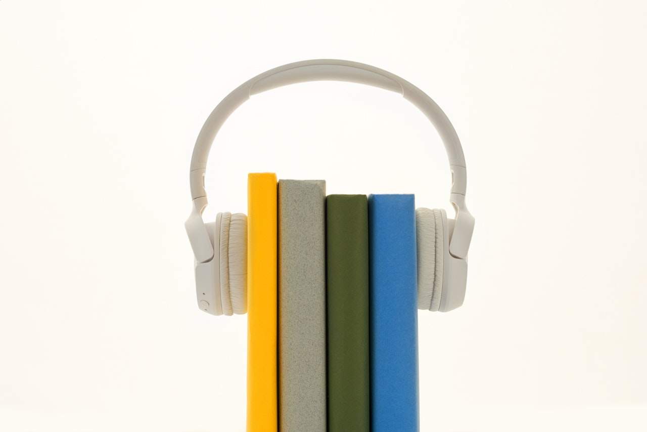 a stack of books with headphones on top of them.