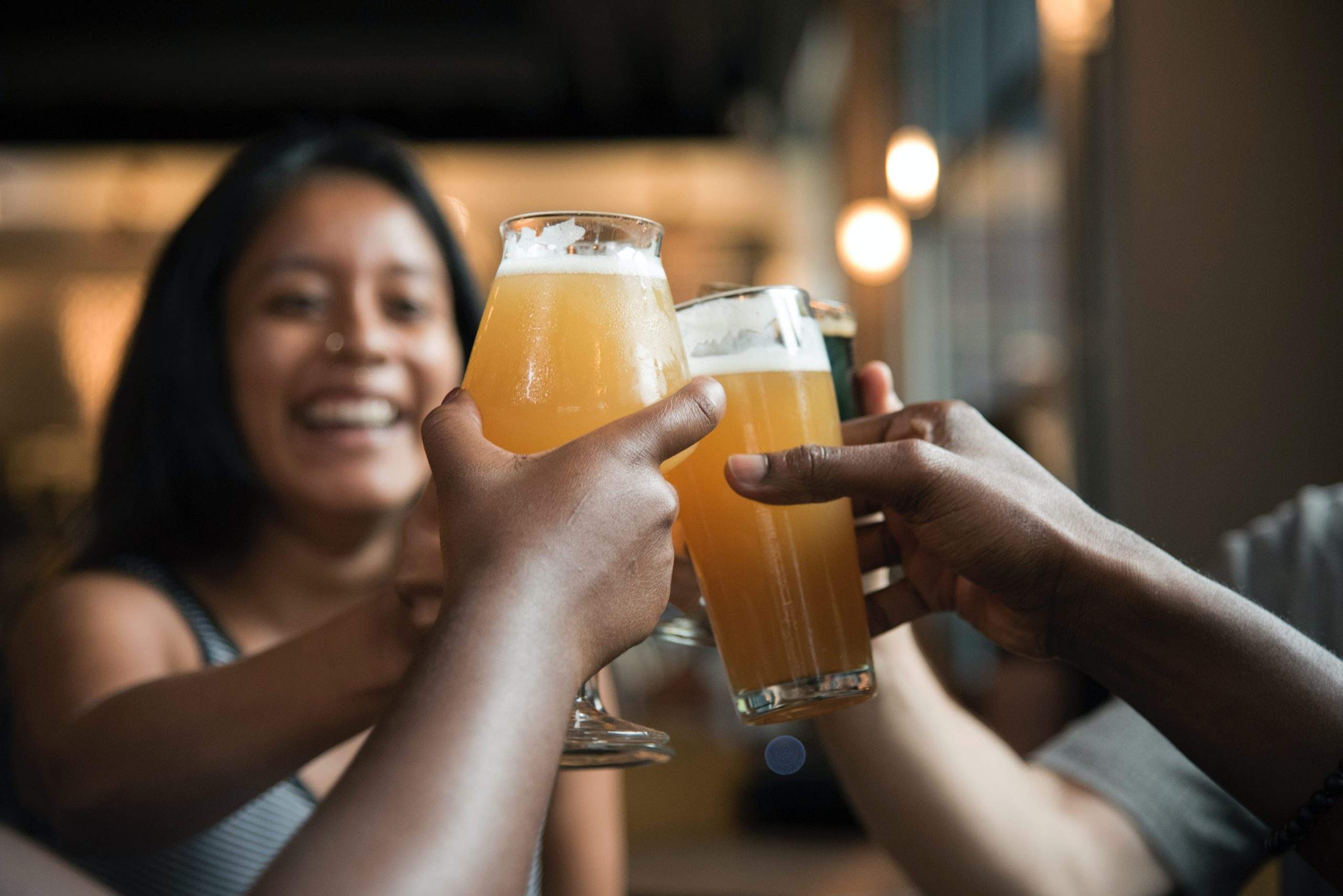 a group of people holding up glasses of beer.