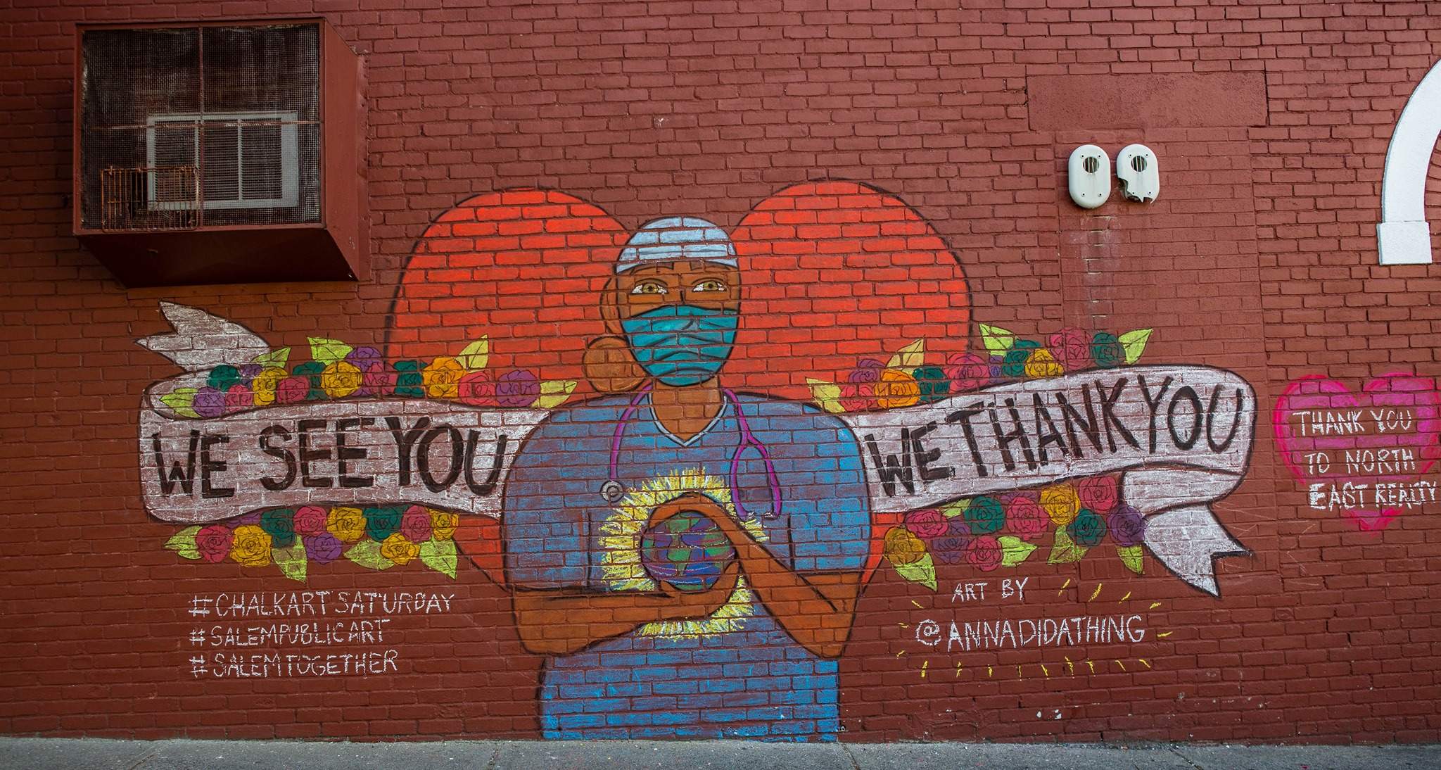 a brick wall with a mural of a man wearing a face mask.