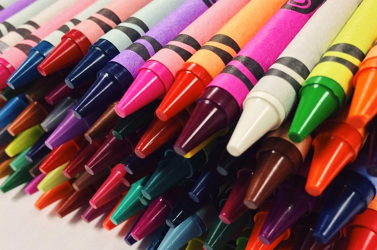 many different colored crayons lined up in a row.