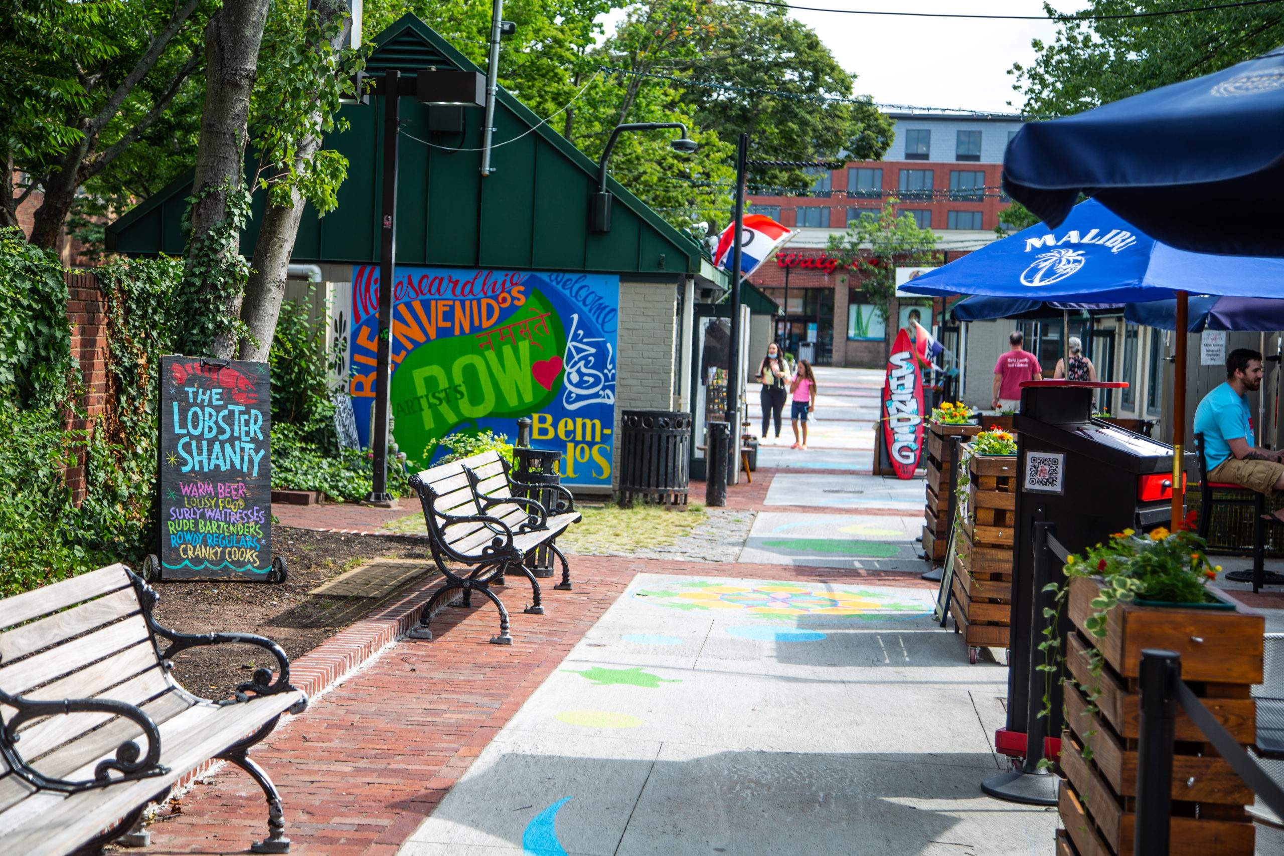 a couple of benches sitting next to each other on a sidewalk.