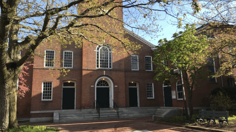 Salem Playhouse’s vibrant red brick exterior, arched doors, and sunny windows welcome our Essex County community amid blooming trees.