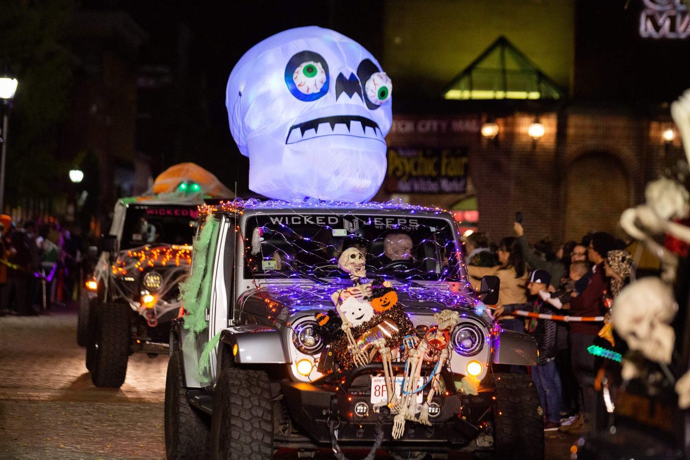 a jeep driving down a street decorated for halloween.