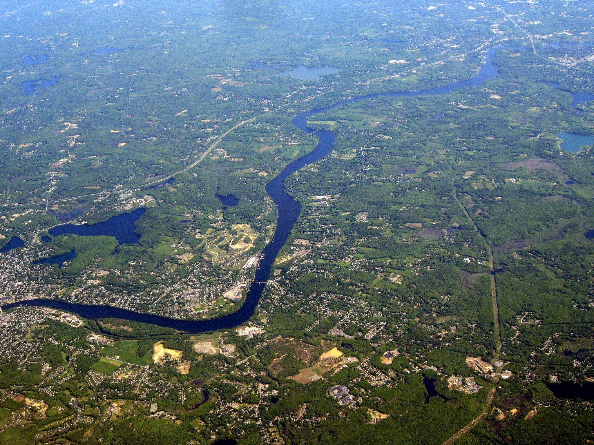 a river running through a lush green countryside.