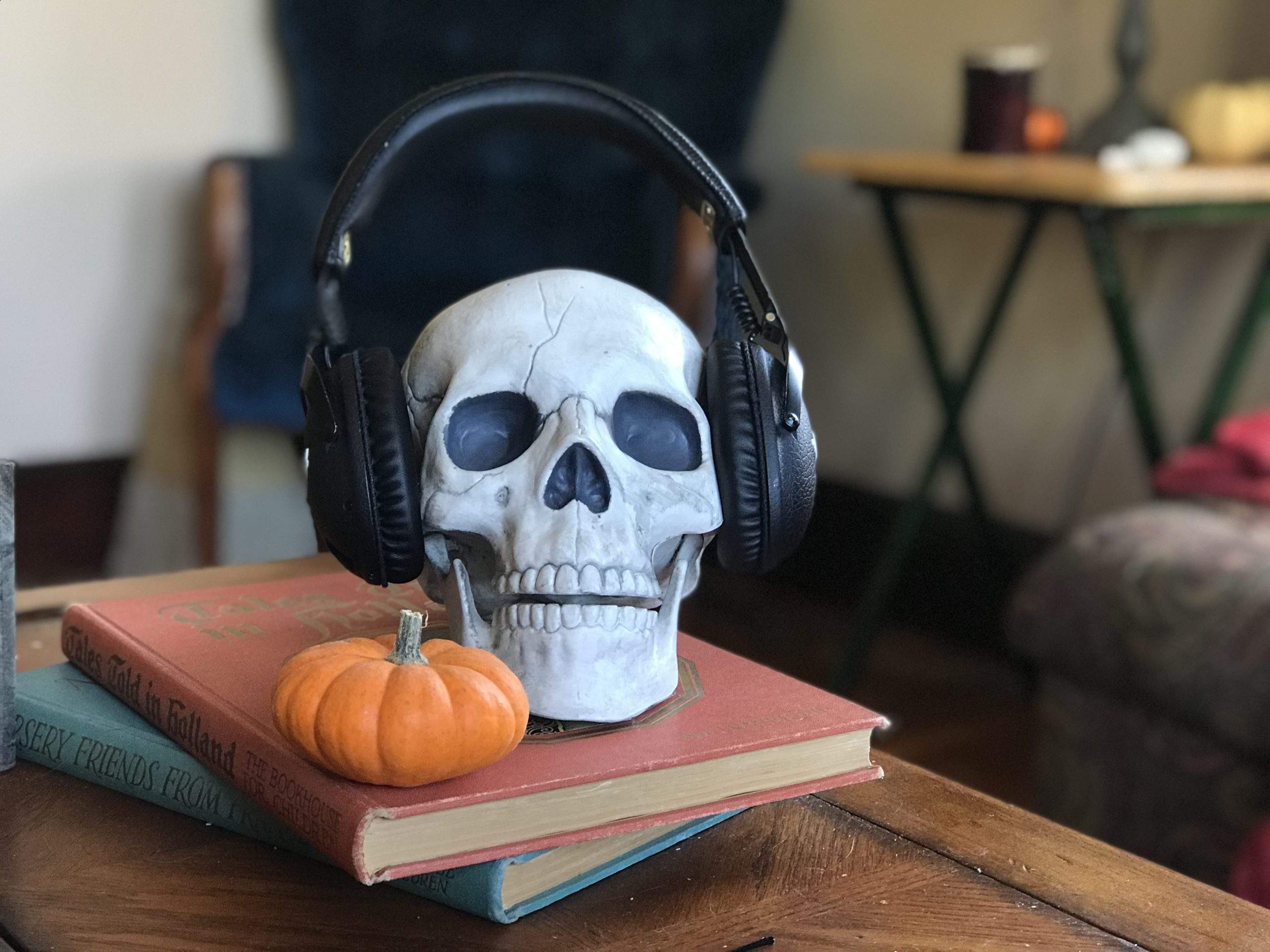 a skull wearing headphones sitting on top of a book.