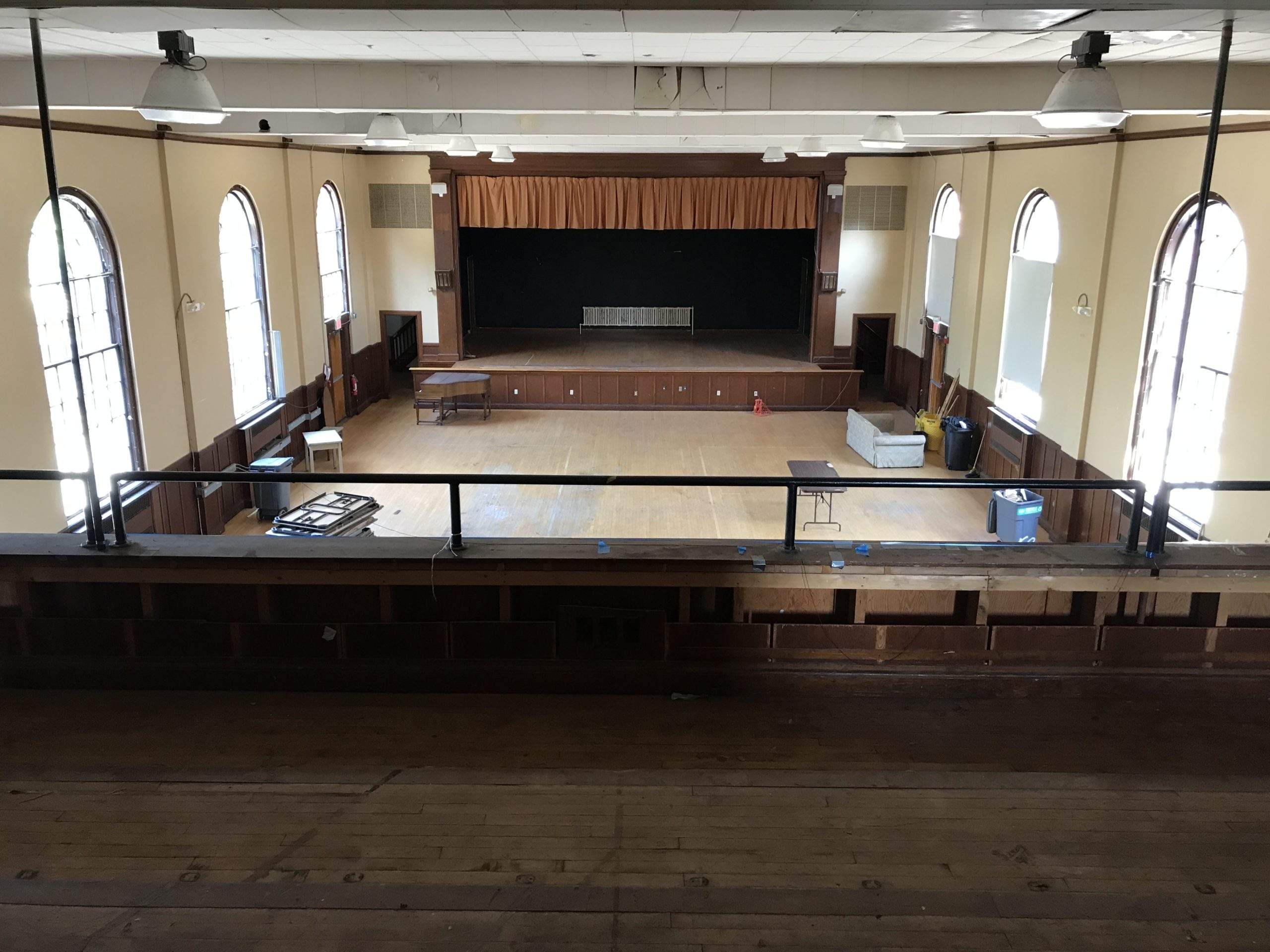 a large empty room with a balcony and a stage.