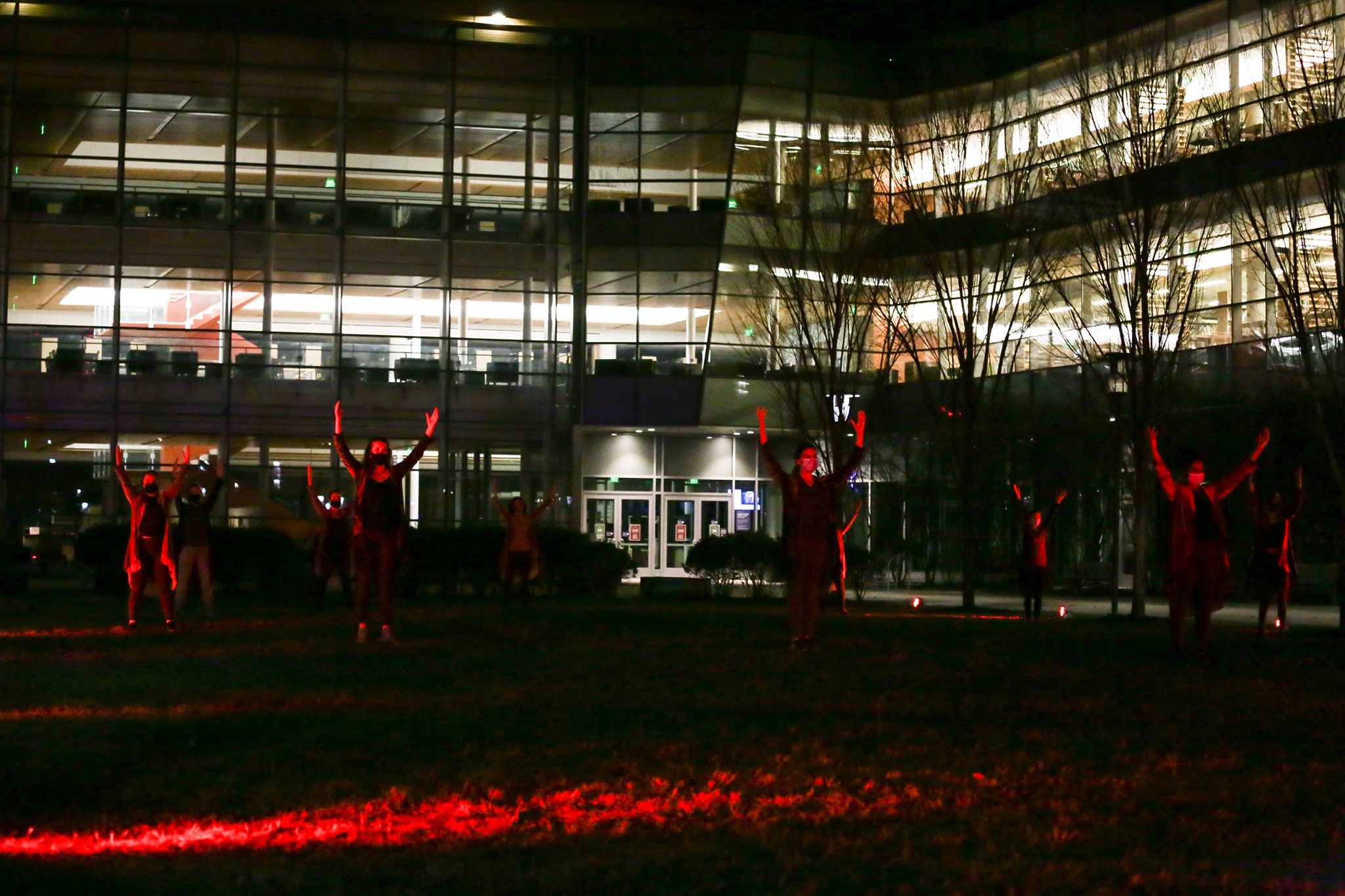a group of people standing in front of a building at night.