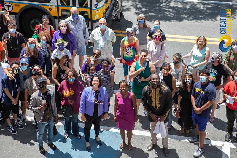 a group of people standing in front of a bus.