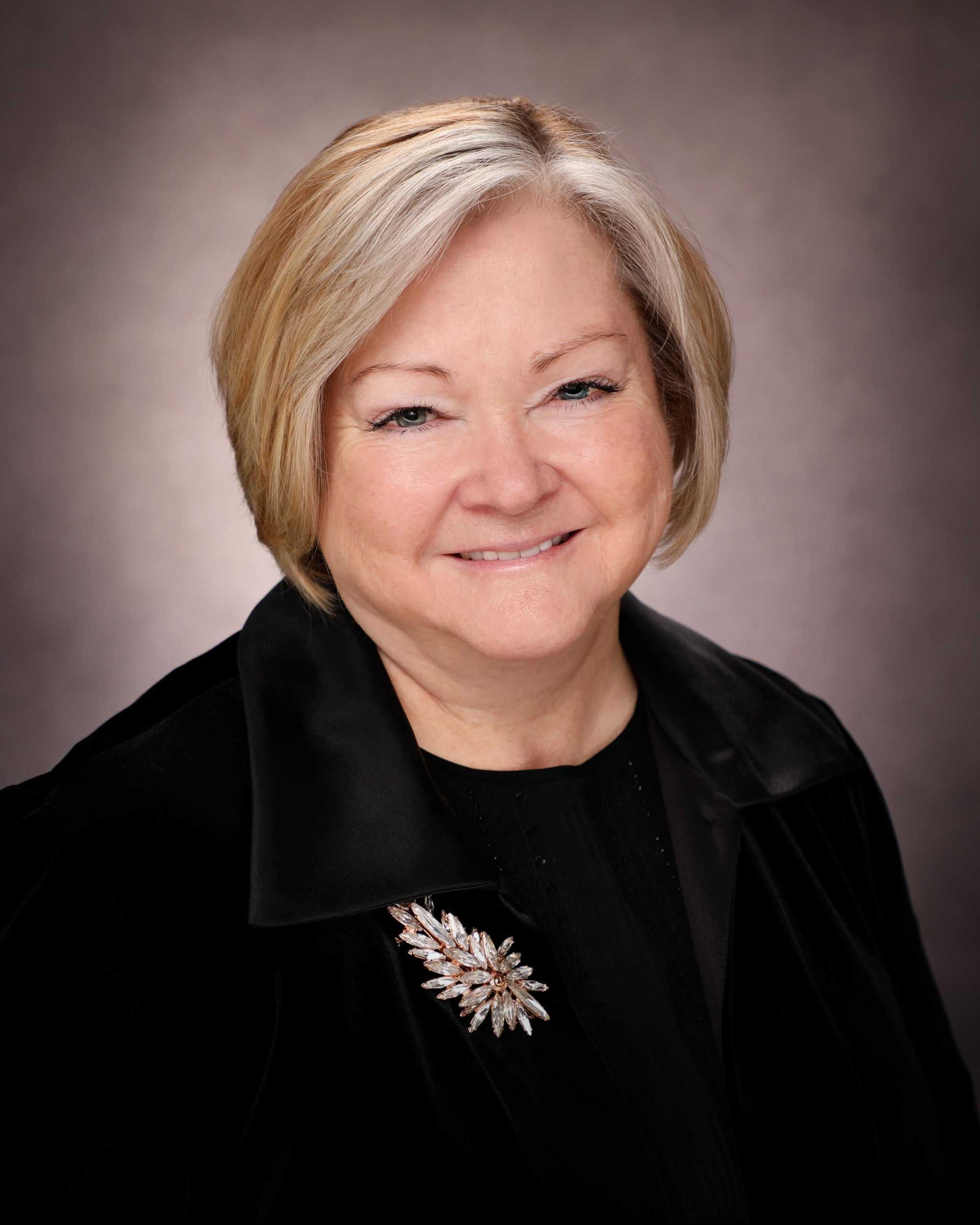 a woman with blonde hair and a black jacket.