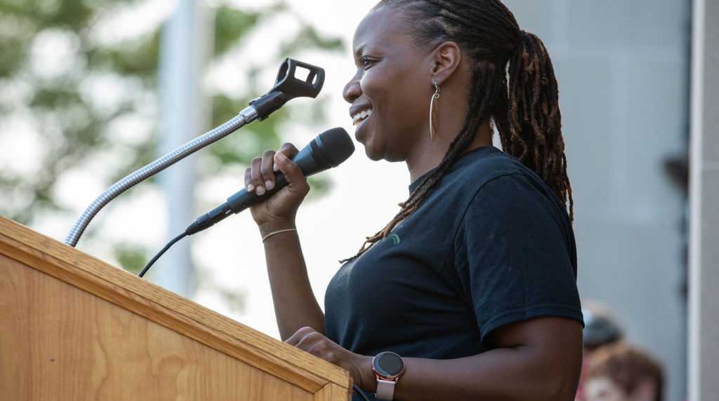 a woman standing at a podium with a microphone.