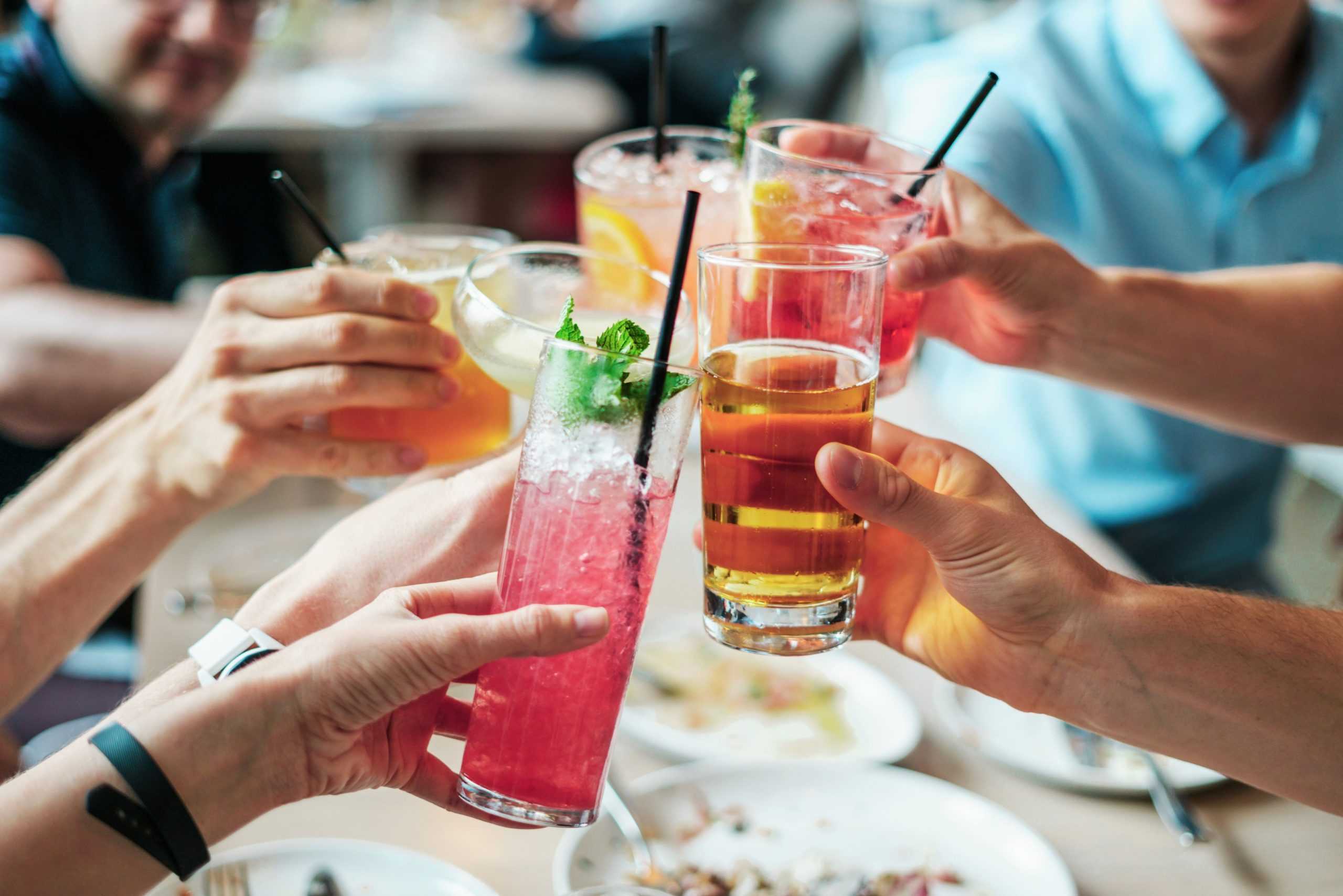 a group of people holding up drinks at a table.