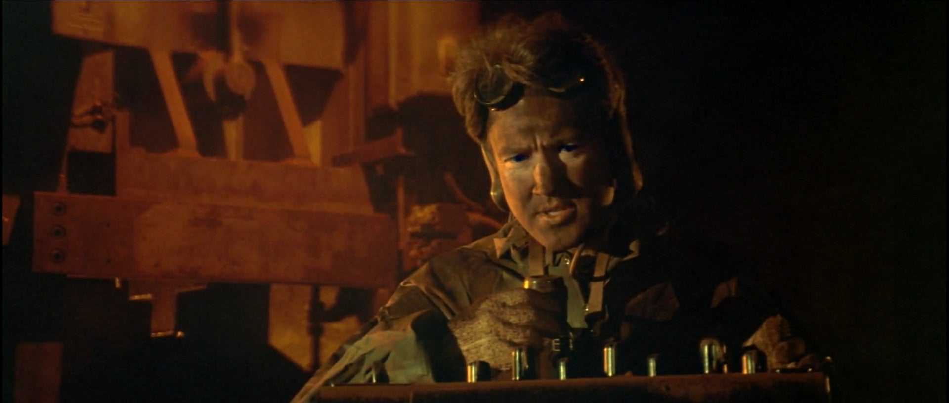 a man standing in front of a table filled with bottles.