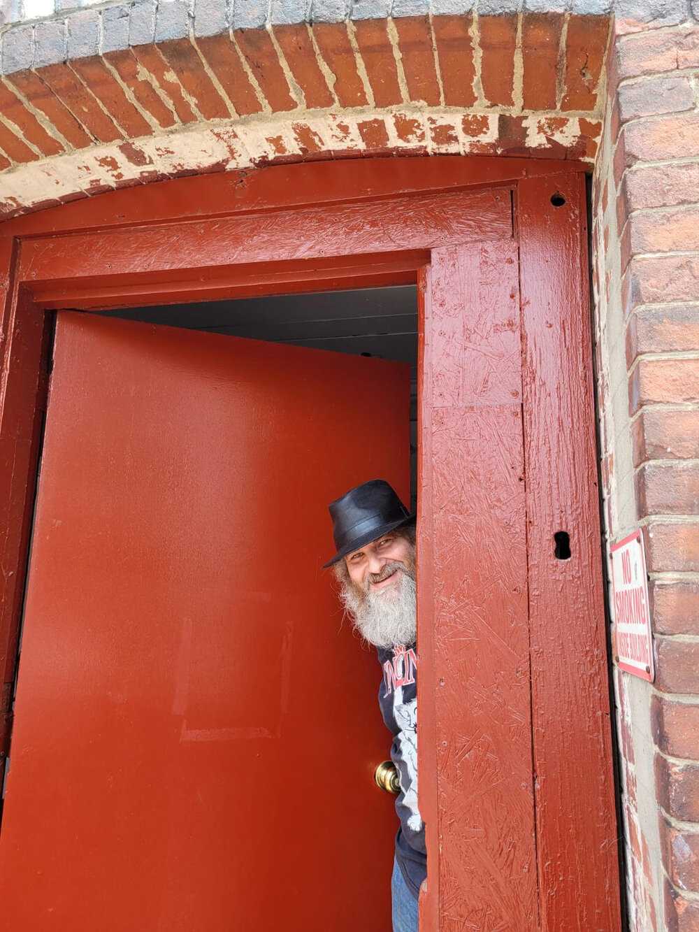 a man with a beard and a top hat standing in a doorway.