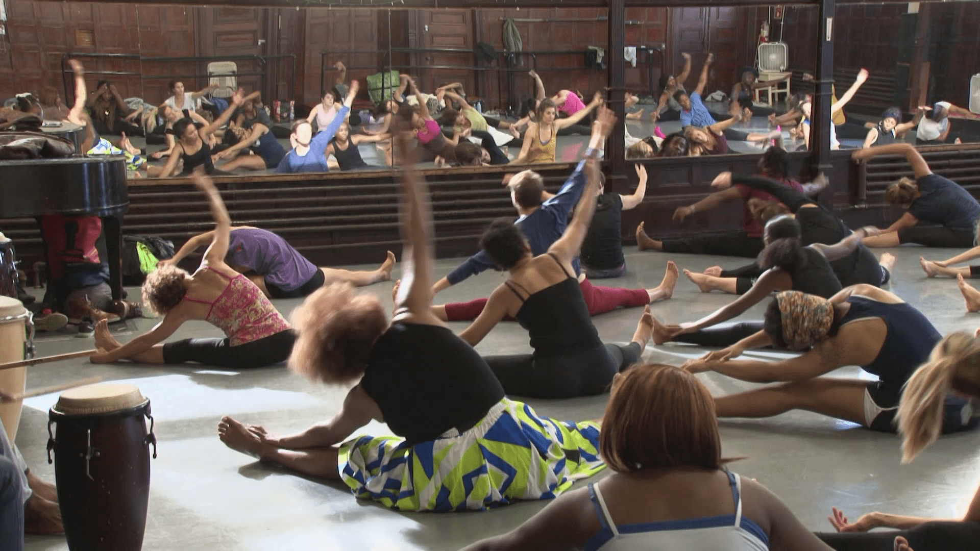 a group of people doing yoga in a large room.