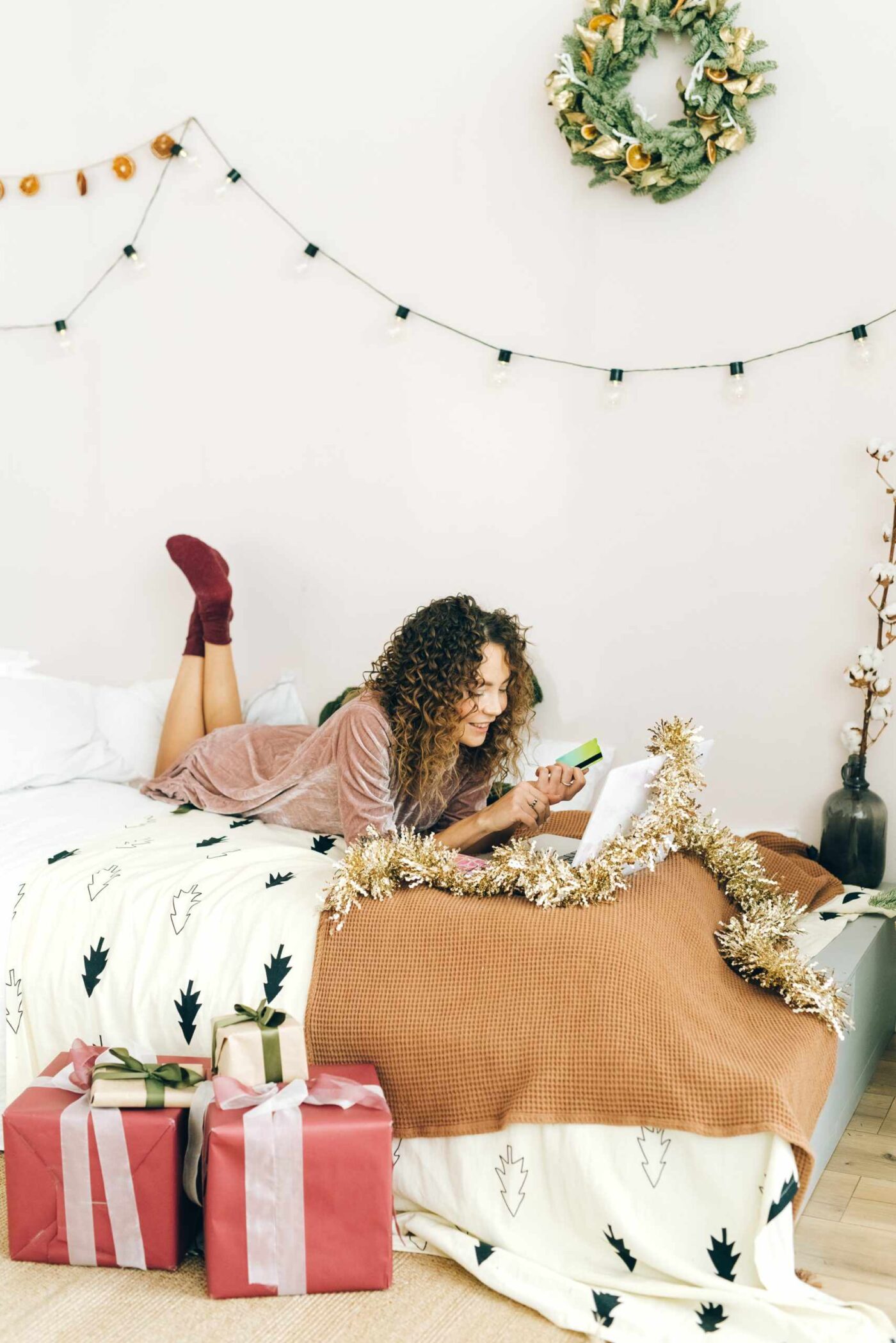a woman laying on a bed surrounded by presents.