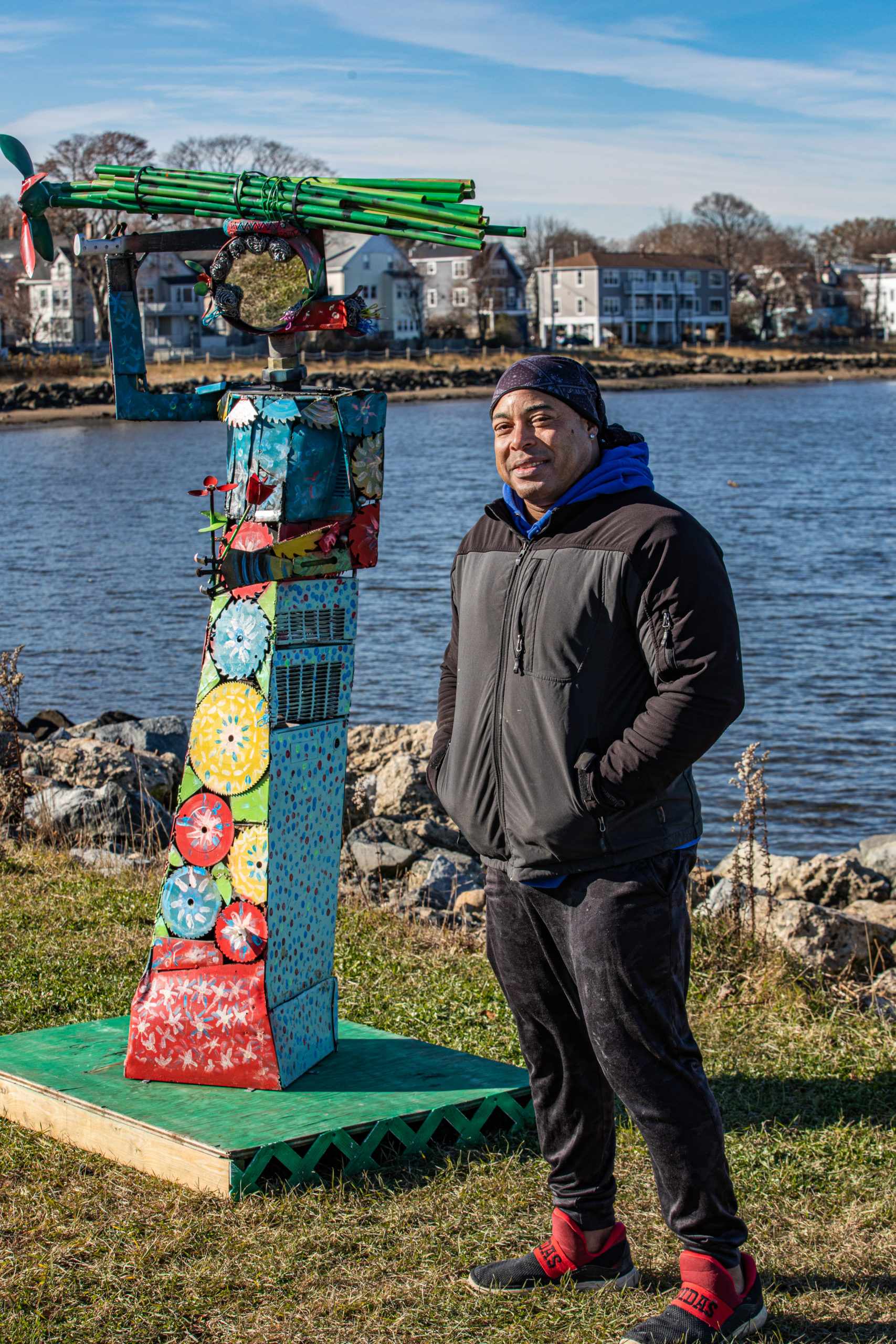 a man standing next to a colorful sculpture.