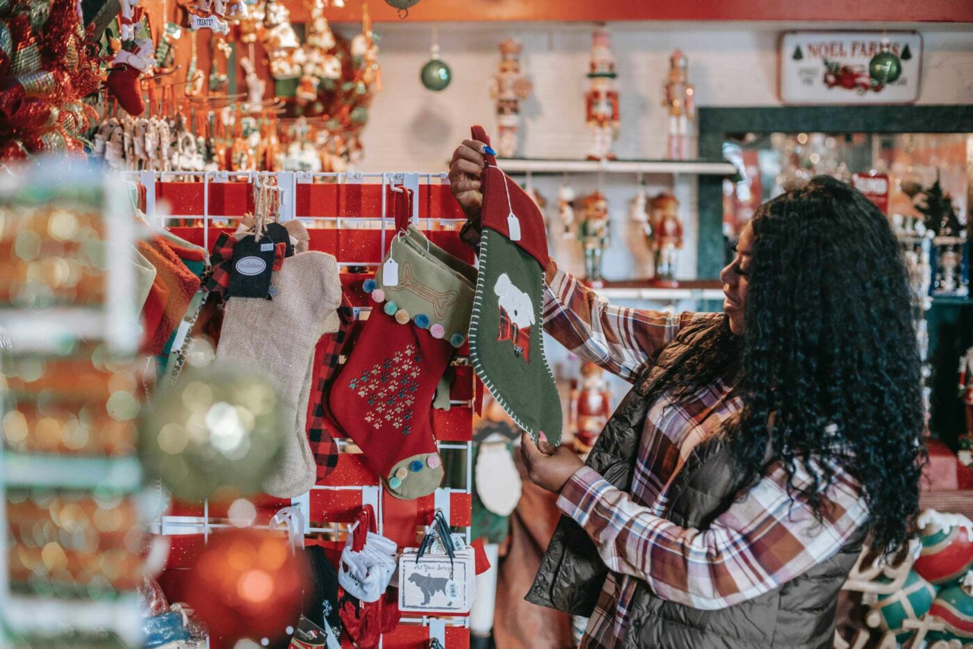 a woman holding a christmas stocking in a store.