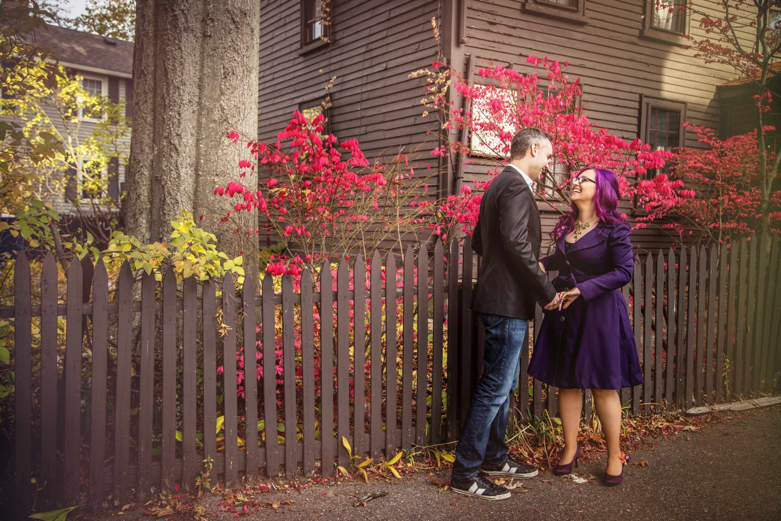 a man and a woman standing next to a fence.