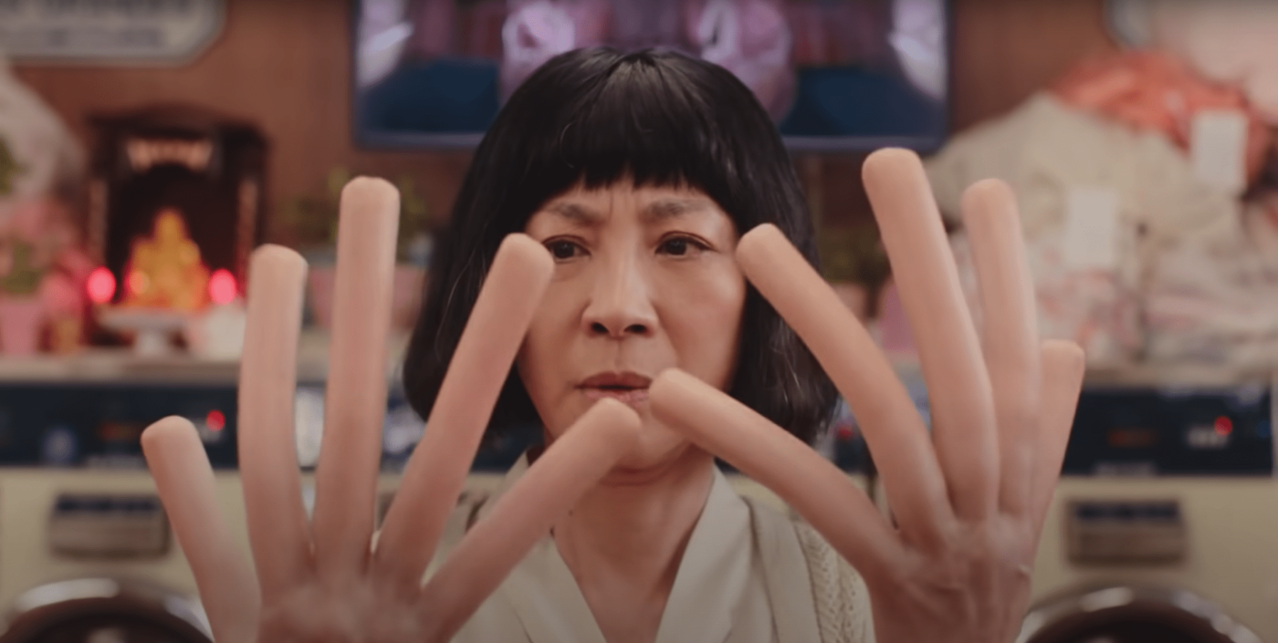 a woman holding her hands up in front of her face.