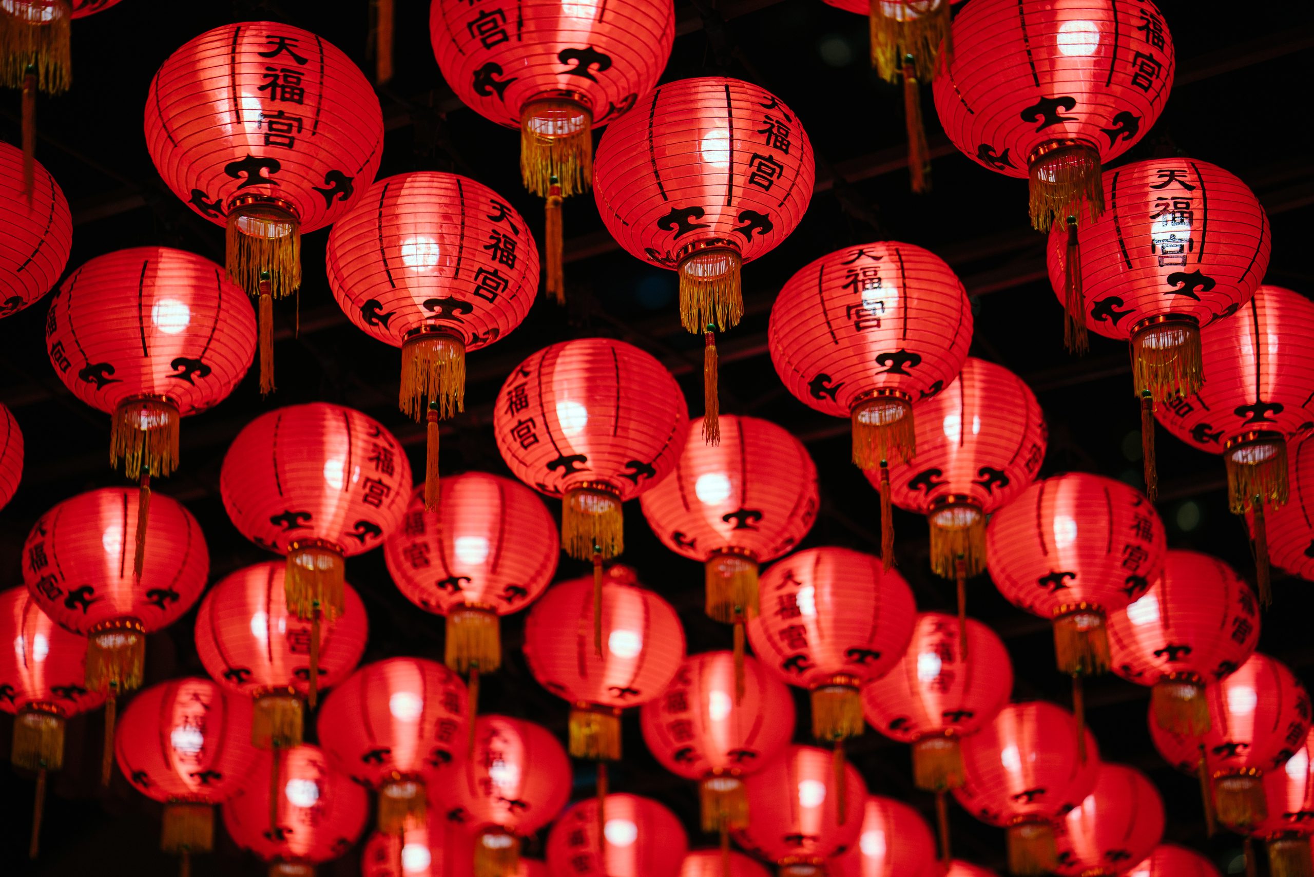 a bunch of red lanterns hanging from a ceiling.