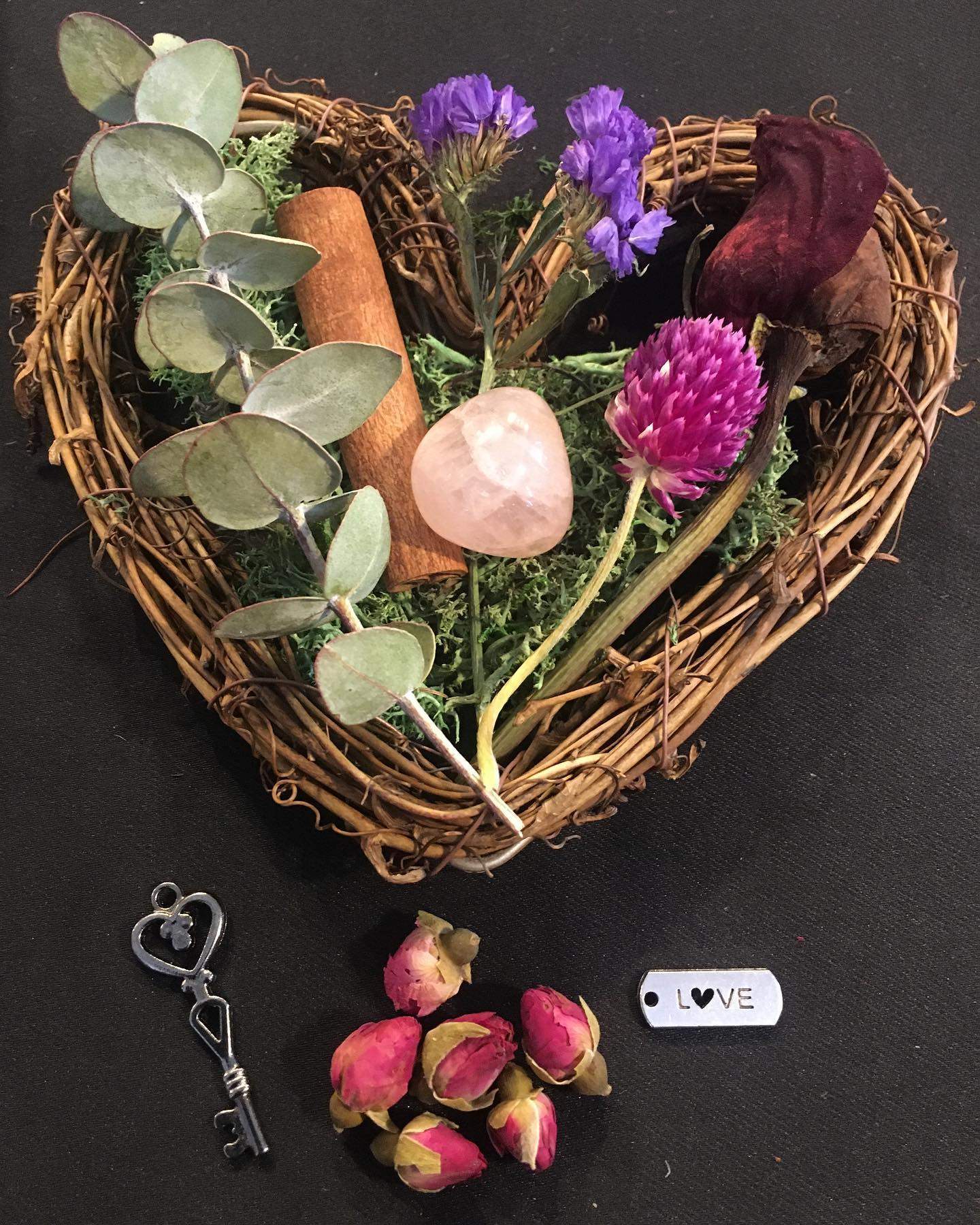 a heart shaped basket filled with flowers next to a pair of scissors.