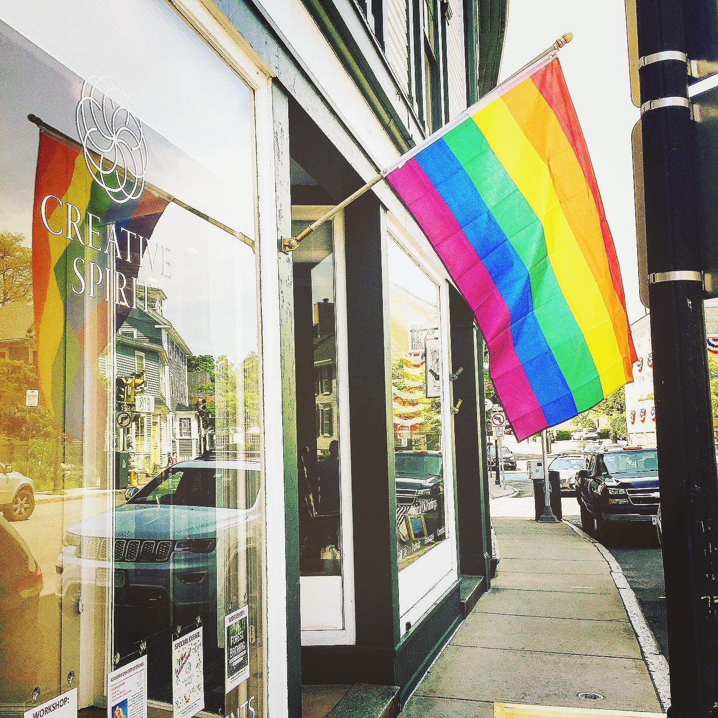 a rainbow flag is hanging outside of a store.