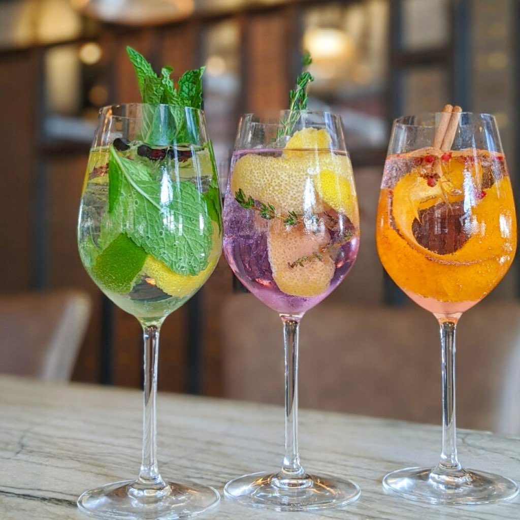 three wine glasses filled with different types of drinks.