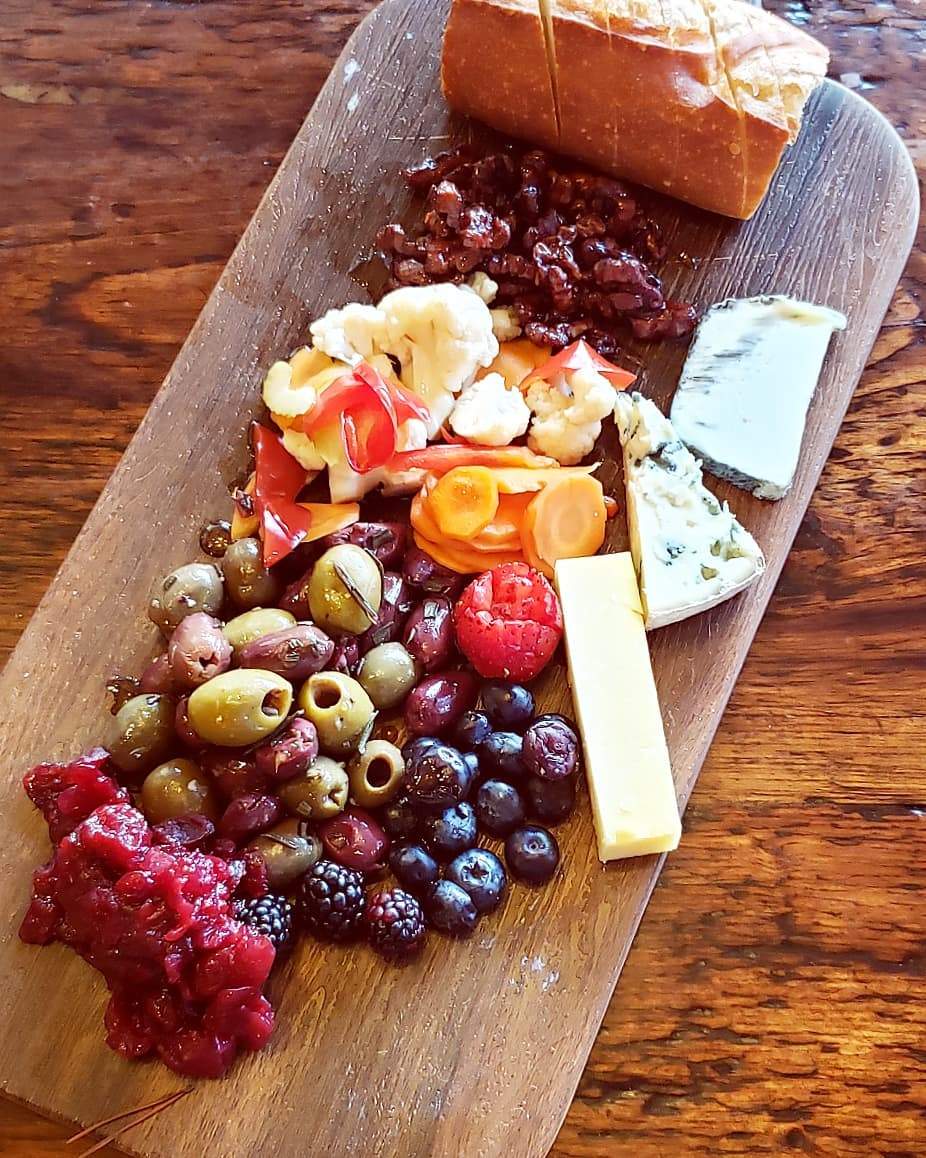 a wooden cutting board topped with lots of food.