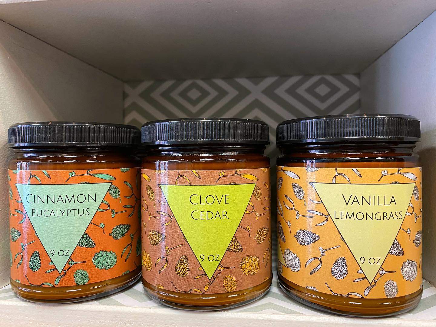 three jars of honey sit on a shelf.
