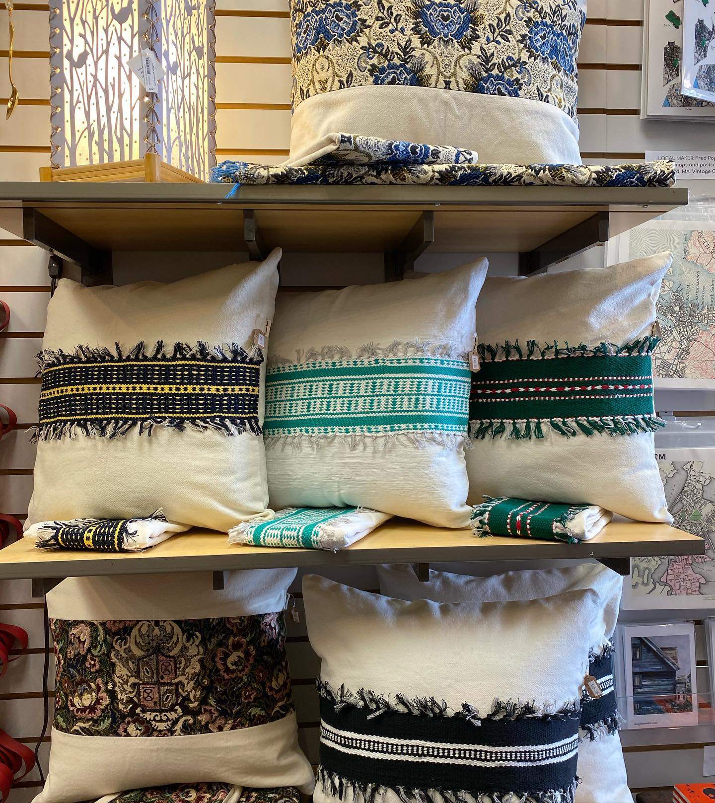 a bunch of pillows that are on a shelf.