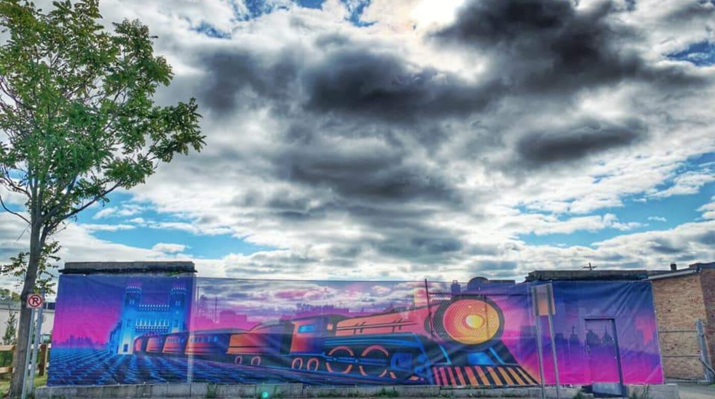 a mural of a train on the side of a building.