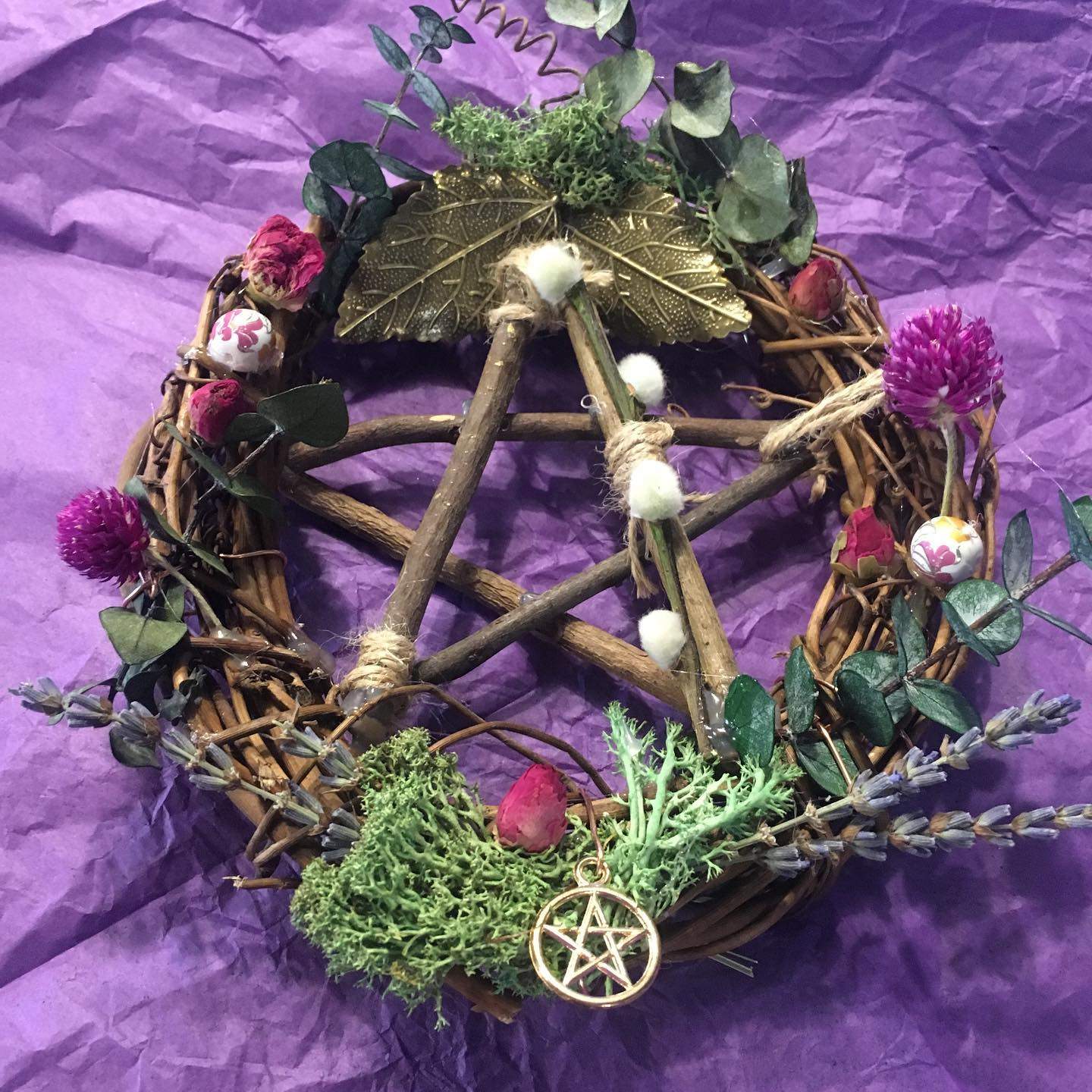 a wicker wheel decorated with flowers and greenery.
