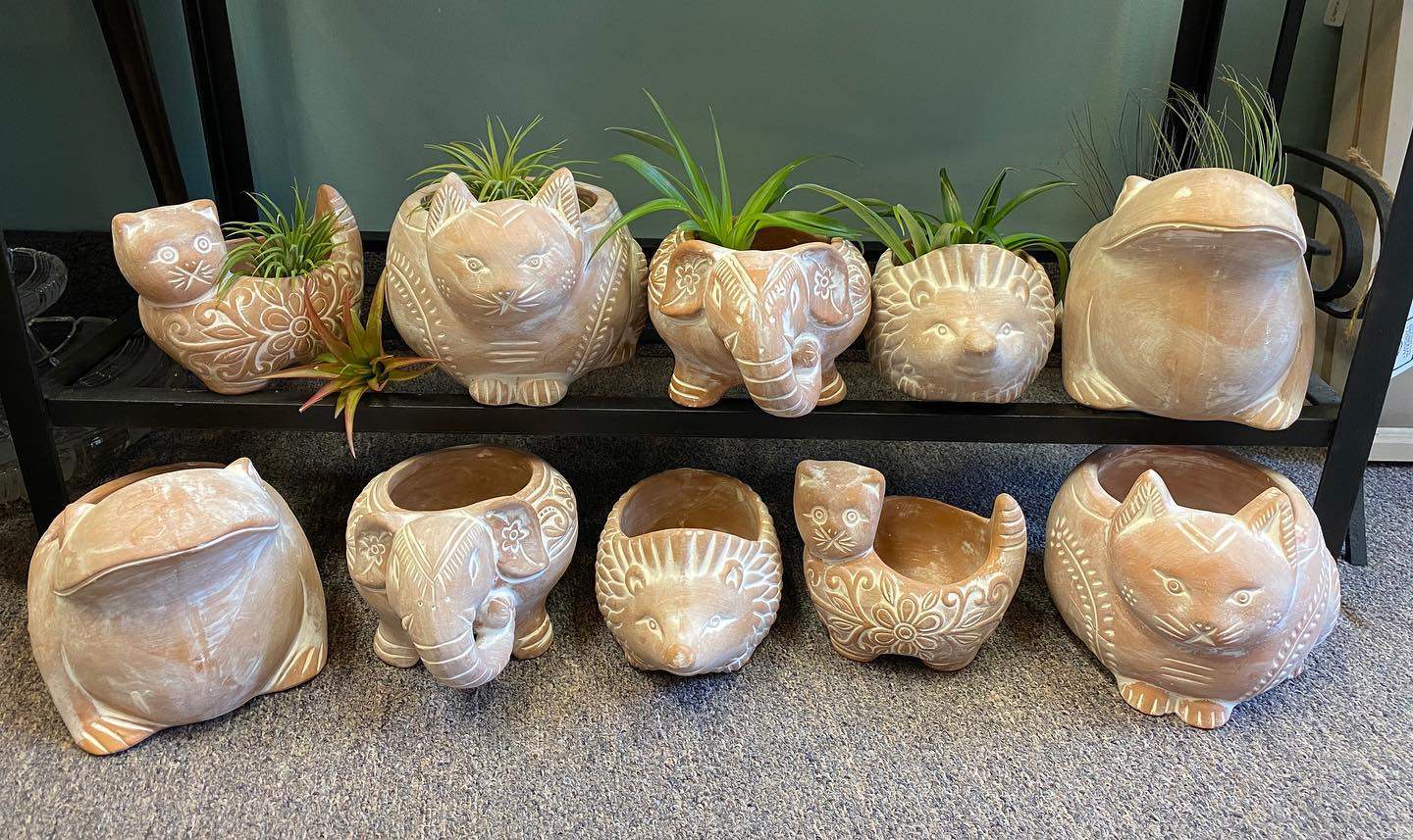 a group of ceramic cats sitting on top of a shelf.