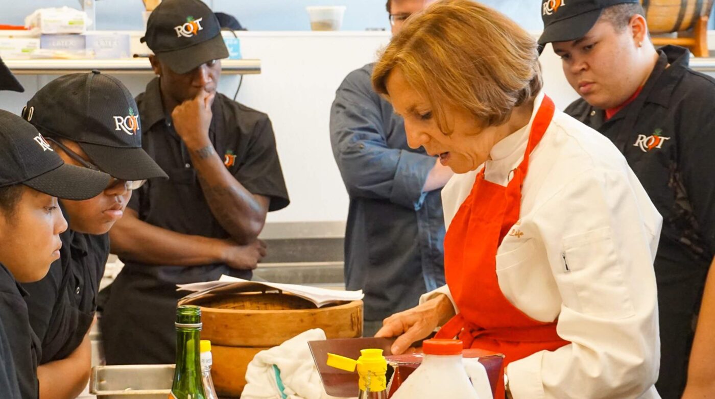 a group of people in a kitchen preparing food.