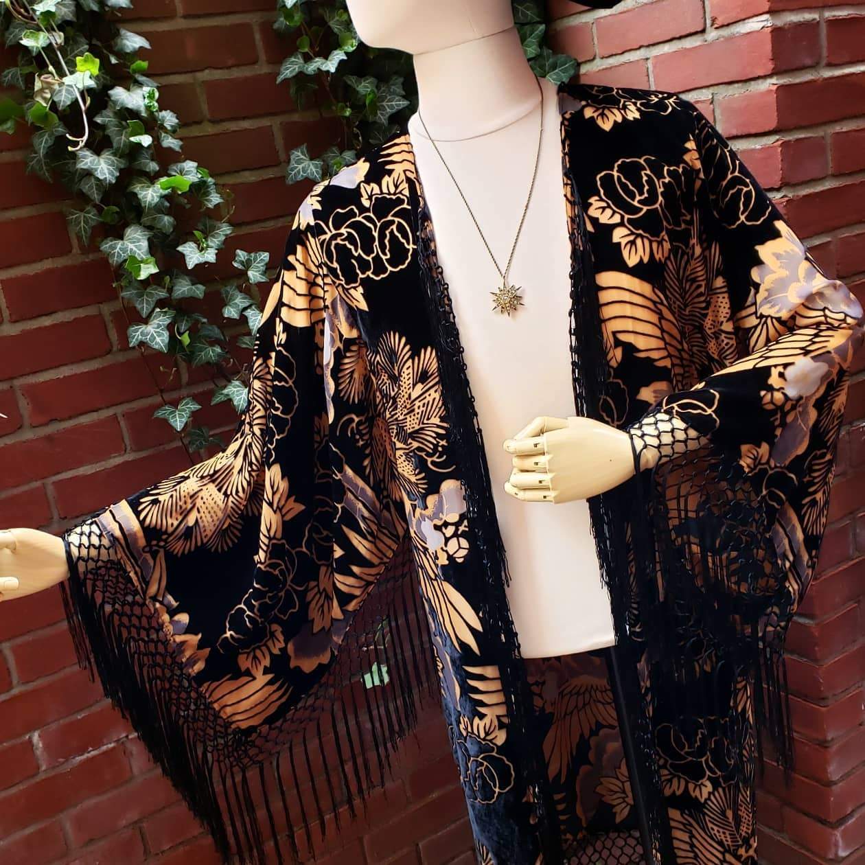 a mannequin wearing a black and gold kimono.
