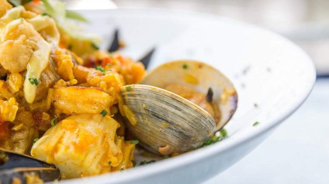 a white bowl filled with food on top of a table.