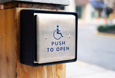 a sign on a wooden post that says push to open.