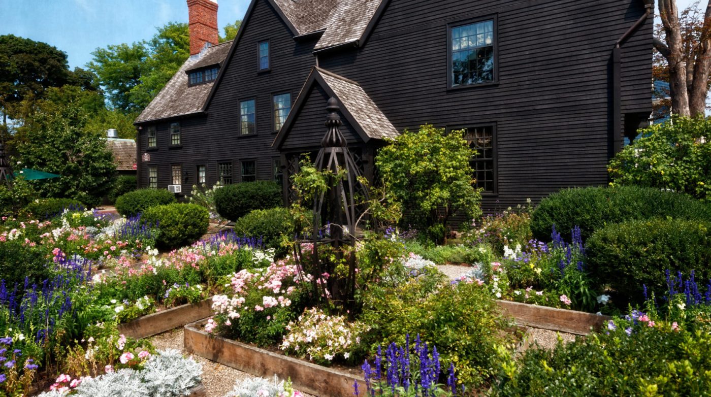 a large black house with lots of flowers in front of it.