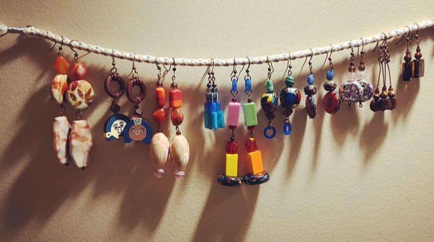 a string of earrings hanging from a wall.