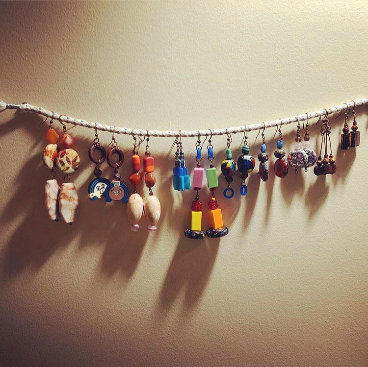 a string of earrings hanging from a wall.