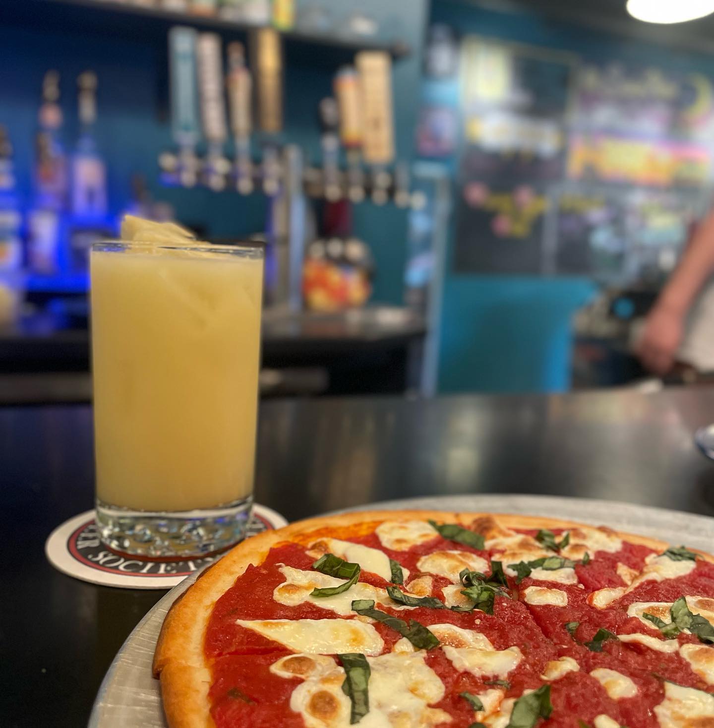 a pizza sitting on top of a table next to a glass of orange juice.