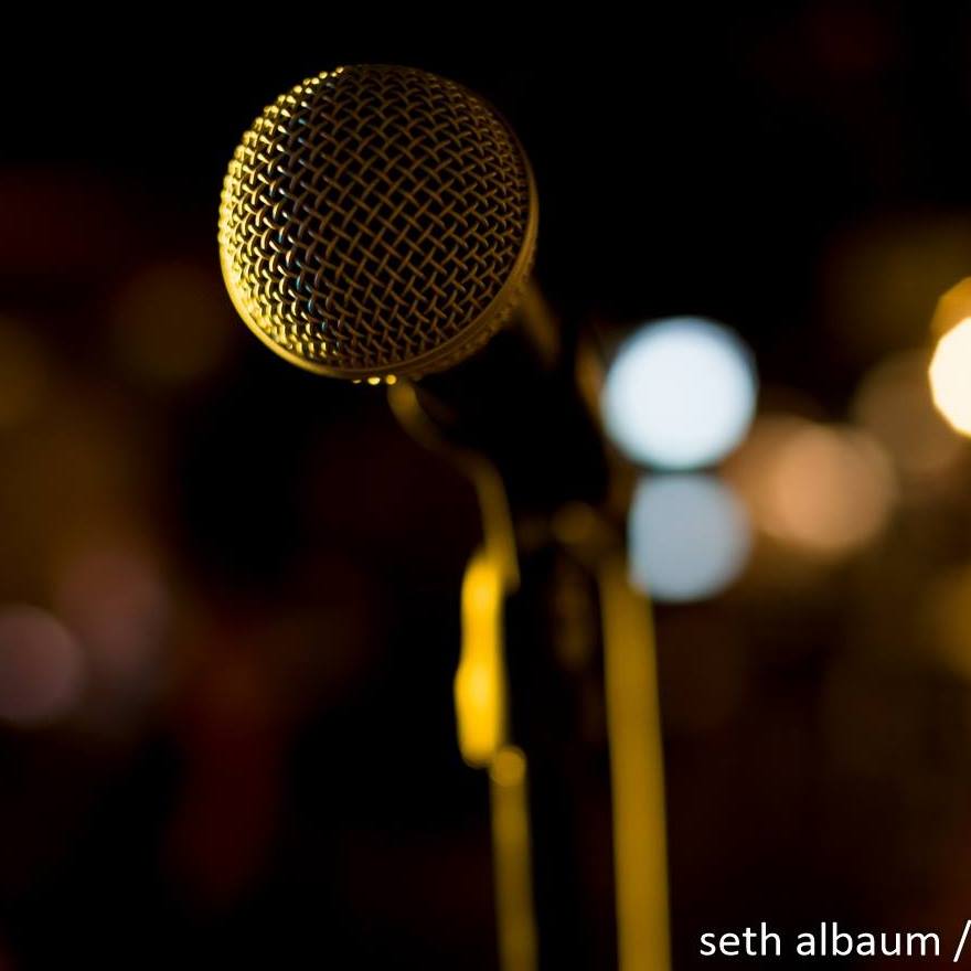 a close up of a microphone with blurry lights in the background.