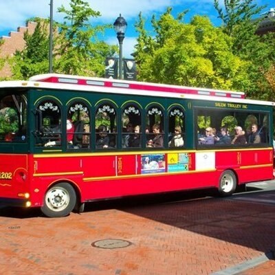 a red and green bus driving down a street.