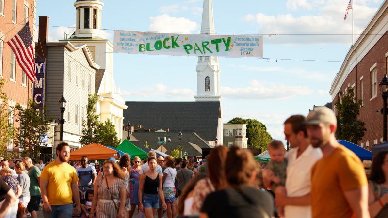 Local residents unite for a fun-filled neighborhood block party under the warm afternoon sun.