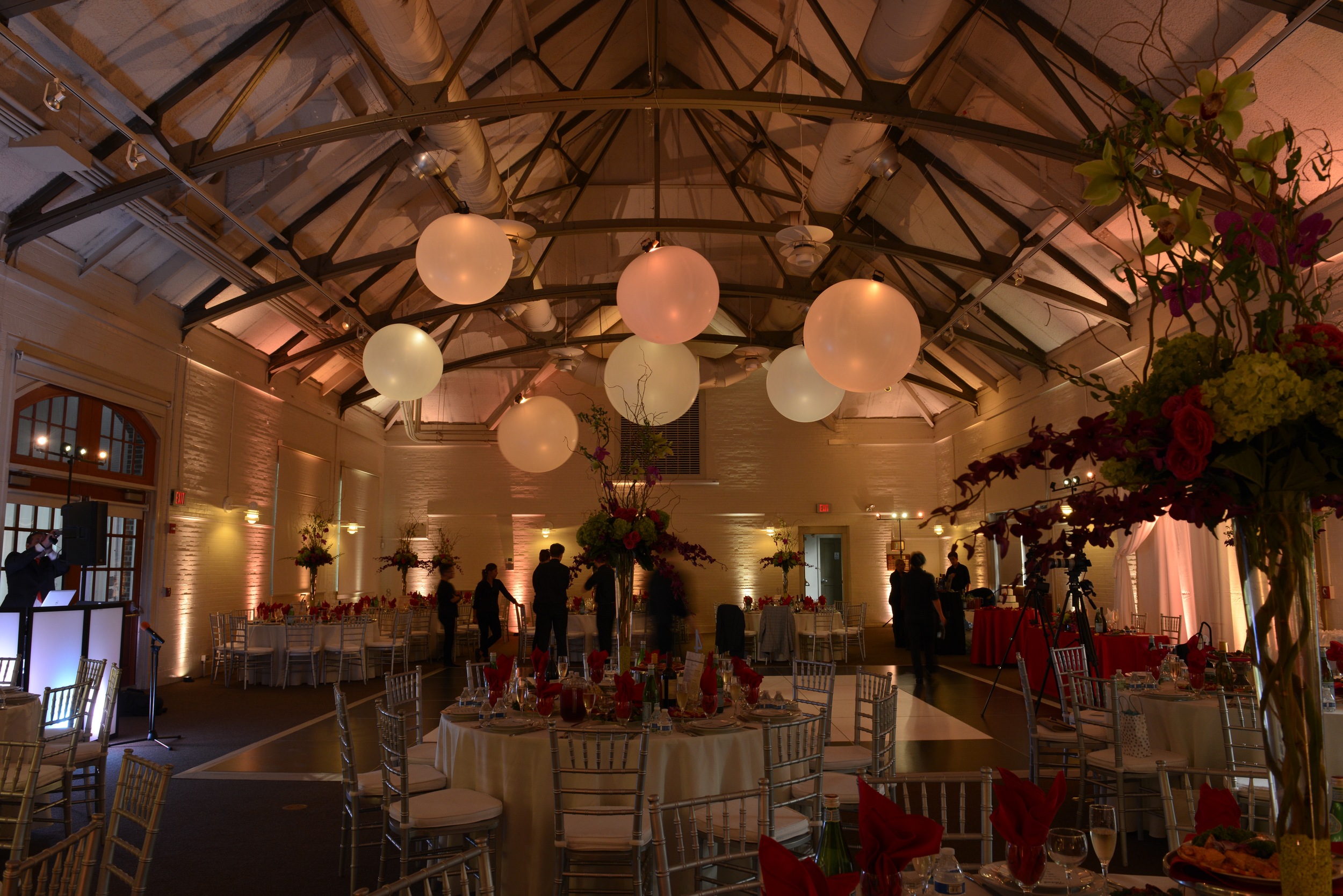the interior of a wedding reception venue is lit with uplighting