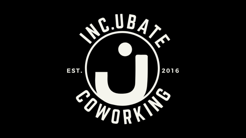A bold white logo on black beams “INC.UBATE COWORKING” around a lively circle and Essex County “j,” sparking local creativity since 2016.