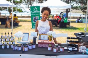 a black woman stands behind a table of cbd products